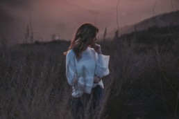 Woman outside in field at dusk